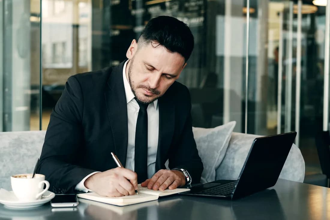 Business owner planning finances with a notebook and laptop