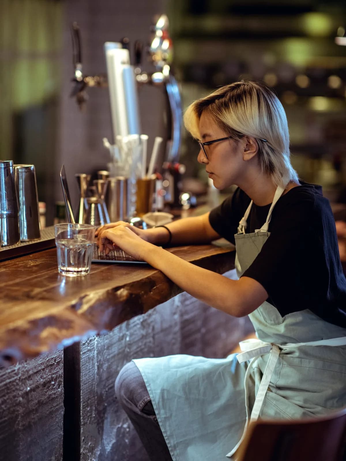 Café owner working on a laptop at her counter