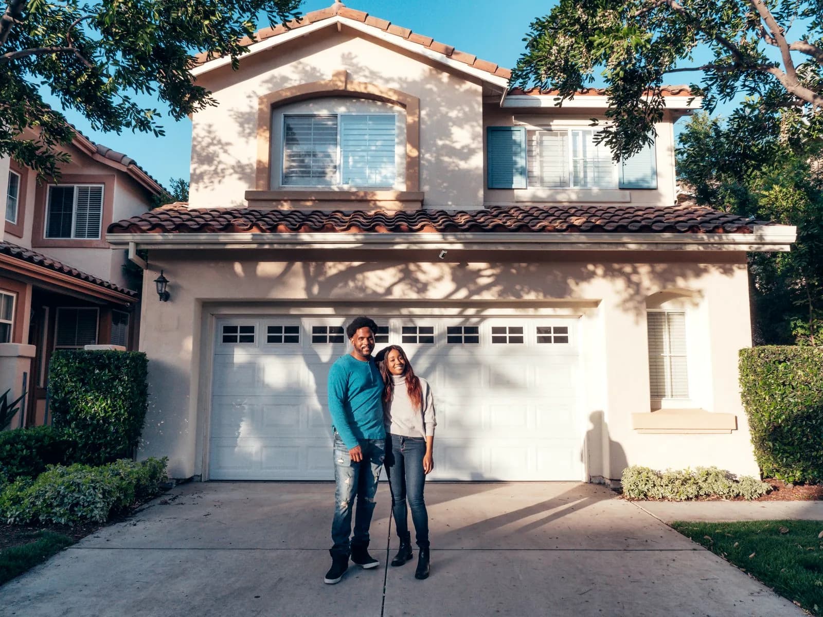 Couple standing in front of their newly purchased house